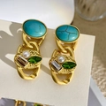 Detail van vintage gouden oorbellen met turkoois en parels op beige kaart - Oorbellen met turquoise parels en groene edelstenen / Zilveren Pin - Goud - Blauw - Groen