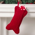 Calza di Natale rossa lavorata a maglia con motivo a trecce su un camino festivo - Calza a Osso / Natale Rosso