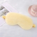 Soft yellow plush sleep mask with elastic strap shown on a cozy decorative background - Yellow