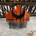 Macro detail of natural red stone hair comb with a black moon accent for bride styling - Red Jasper Black Moon