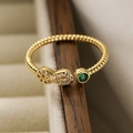 Anello aperto infinito dorato con zirconi e gemma verde su scatola di legno - Infinito Oro Zircone Verde