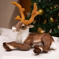 Lying plush reindeer doll in brown and white with festive Christmas tree background - Ordinary Prone Small / 35 cm