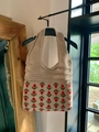 Detailed macro view of beige crochet tote bag with red and green floral knit patterns - Khaki