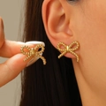 Detailed close-up of golden bow-shaped stud earrings with intricate woven rope texture - Bowknot Shape (8653)