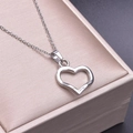 Silberne hohle Herz-Halskette auf einer luxuriösen Champagner-Geschenkbox im Detail - Halskette / Silber