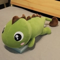 Zachte groene dinosaurus knuffel liggend op bed met bruine stekels, ideaal voor het slapen - 110cm / Groen met bruine rugvinnen