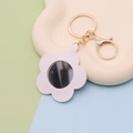 Detail shot of white leather flower keychain with integrated mirror and gold metal clasp - Flower White