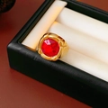 Dettaglio di un anello dorato vintage con una grande gemma rossa ovale sfaccettata - Oro-Rosso