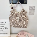 Détail du sac cabas en toile imprimé léopard cœur avec breloque nuage pelucheux - Velours côtelé léopard cœur beige