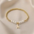 Golden beaded bracelet with white pearls and a beige coral pendant on silk background - Beige