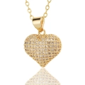 Detalle del collar con colgante de corazón dorado y micro-pavé de circonitas sobre fondo blanco - Blanco