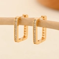 Macro shot of gold-plated geometric hoop earrings with clear cubic zirconia on wood branch - EH225 Rectangular Single Row