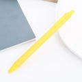 Single yellow retractable gel ink pen placed on a minimalist gray notebook and white plate - Retro Yellow