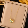 Golden heart necklace featuring an evil eye pendant inside a beige jewelry display box - H1200 Necklace Gold