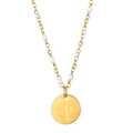 Detail of gold necklace with white beads and a circular cactus silhouette pendant - Cactus