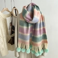 Detail showing colorful rainbow knit scarf with mint green pom-poms on beige coat - Tiffany Blue