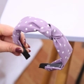 Dettaglio di un cerchietto a pois viola con nodo in tessuto morbido e ampia base antiscivolo - Viola a pois bianchi annodato