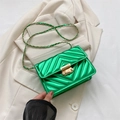 Borsa a tracolla trapuntata verde con catena dorata e finitura metallica su blazer beige - Verde