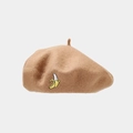 Close-up of beige wool beret featuring a detailed yellow banana embroidery pattern - Khaki