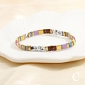 Macro detail of Bohemian Tila bead bracelet with colorful tiles on a shell dish - Marble Blue & Brown Set