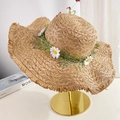 Straw beach hat with daisy flower wreath and fringe brim on golden display stand - Khaki Daisy Frayed Edge