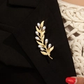 Spilla vintage foglia di ulivo dorata con perle su risvolto di blazer nero per look chic - Stile Perla Dorata