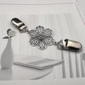 Détail macro d'un clip cardigan fleur argentée avec boucles bec de canard sur bureau - Style 8 (Fleur creuse à six pétales en argent)