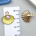 Golden shell alloy pendant with yellow enamel and pearl inlay shown with ruler - Yellow Pearl Shell