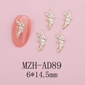 Macro detail of golden metal angel wing nail charms with hollow carving texture - Gold Angel Wings (AD89)