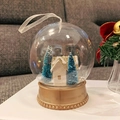 Palla di neve natalizia con casetta bianca, alberi blu e base dorata per decorazioni - Casa d'Oro