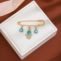 Detail of gold brooch with blue evil eye charms and Hand of Fatima in a gift box - Crystal Hamsa Style (Z295)