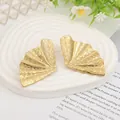 Detailed close-up of golden ginkgo leaf earrings with brushed metallic texture on tray - Gold EH002 (Ginkgo Leaf Shape)