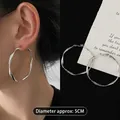 Dettaglio macro di orecchini a cerchio geometrici argento da 5 cm su modella e piano - 6# Argento Grande (Diametro circa 5cm)