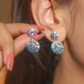 Sparkling snowflake earrings with gradient blue and purple rhinestones on a model - Colorful