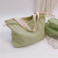Detail of light green corduroy lunch bag with cream handles and drawstring closure - Bean Green