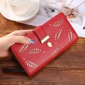 Detail einer roten langen PU-Leder-Brieftasche mit Blattdesign und Goldanhänger - Burgunderrot