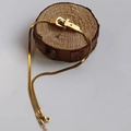 Gouden slangenschakelketting met gesphanger op een houten standaard - Goud