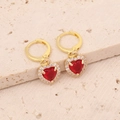 Detail of gold heart earrings with red crystal and white zircon on stone background - Red Earrings