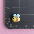 Close-up of yellow resin bee charm on a ruler showing 1.5cm width and 1cm height - Mini Bee
