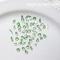 Flatback emerald green mixed shape nail art rhinestones on a white ceramic plate - Approx. 100 Pcs / Light Green