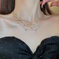Detail shot of elegant multi-layered gold necklace with clear zircon pendants on a model - Gold Layered White Round Necklace