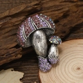 Spilla vintage a fungo in argento con strass viola e rosa su sfondo di legno di foresta - Viola