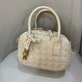 Mini cream woven leather pillow bag with top handles and gold knot charm detail - Sand