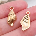 Pair of small gold metal conch charms for DIY jewelry making held in hand - Conch Pendant 9x19mm