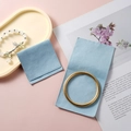 Light blue microfiber snap jewelry pouch showing a golden bracelet inside a soft suede bag - Microfiber Flap Pouch / 7*7cm / Light Blue