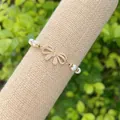 Macro shot of 18K gold plated bow charm with sparkling crystals and white pearls - Style 3(3)