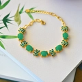 Macro shot of gold lotus flower enamel and green jade charms on the vintage bracelet - 16+3cm / Jasper Green