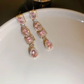 Dettaglio di orecchini dorati con pietre rosa e pavé di cristalli su base di ceramica - Perno per orecchini in argento - Rosa