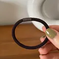Close-up of coffee brown thick elastic hair tie with textured twill weave and smooth connector - Dark Coffee