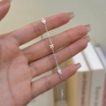 Pulsera de plata esterlina S925 con delicados dijes de flores de cinco pétalos al pulso - Plata 925 / Oro Blanco